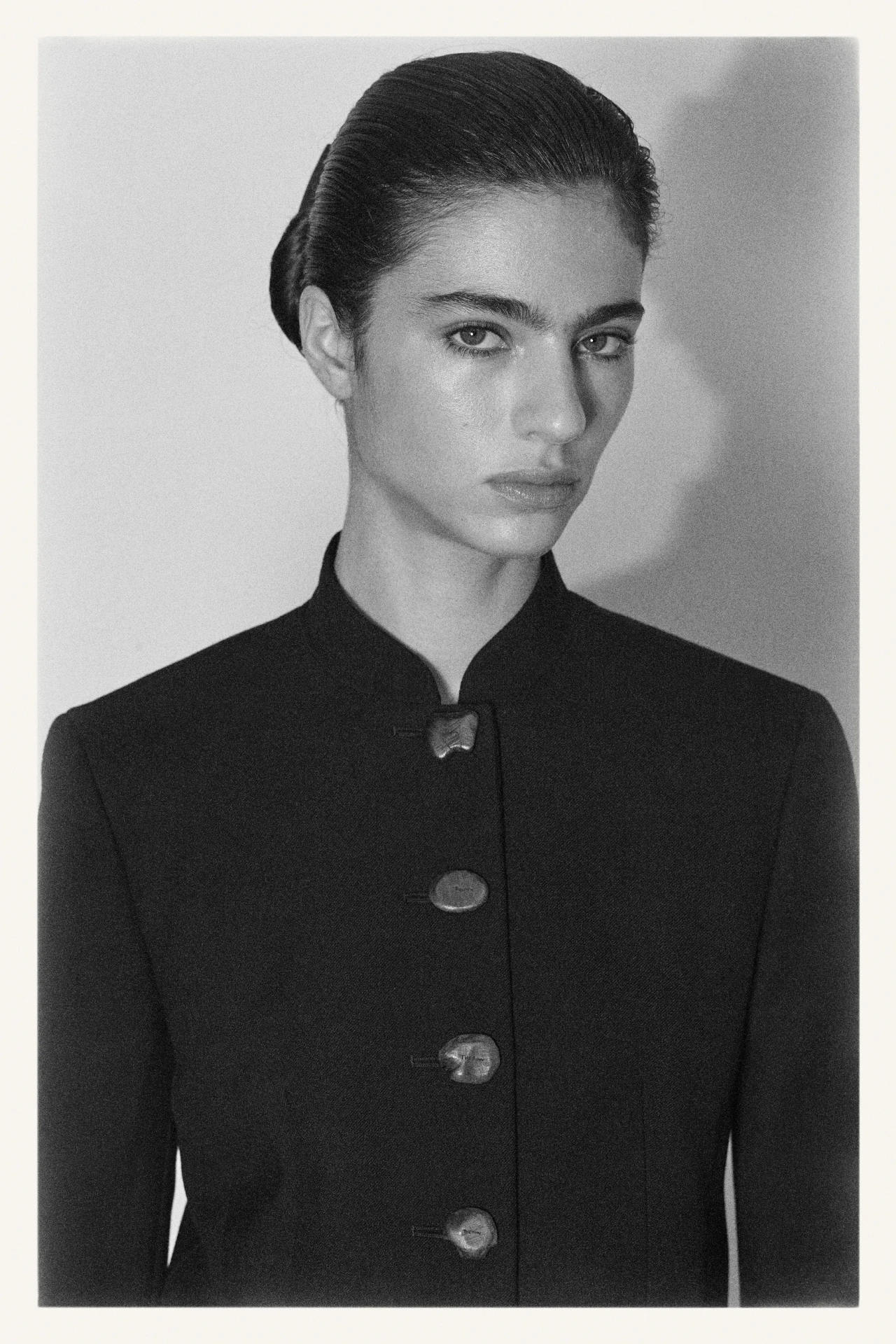 Black and white portrait, tailored mandarin-collar jacket. The Row, pre-fall 2026